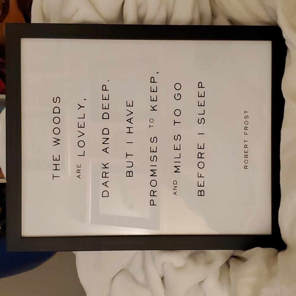 A Robert Frost quote in a black frame